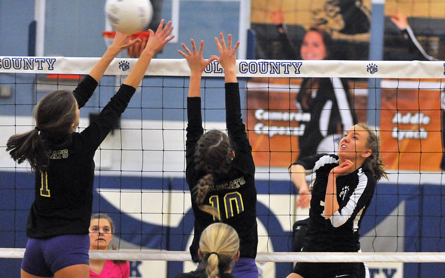 Freshman Grace Lauer splits a West Stokes block for a point during Wednesday's match.