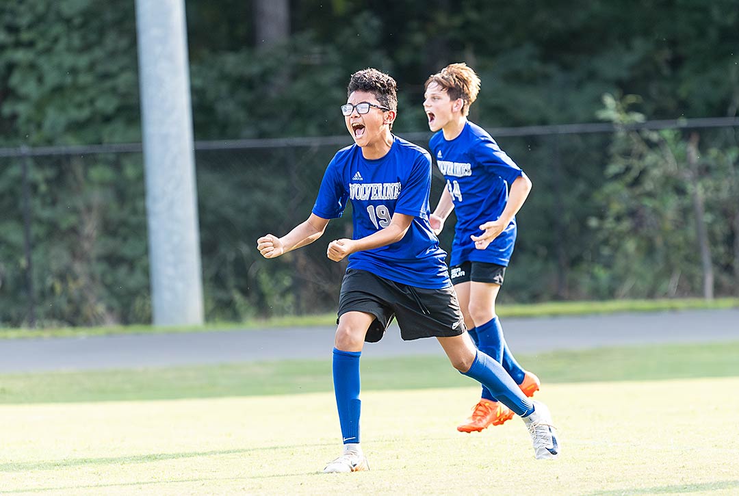 Polk County Middle's Angel Roman (19) and Rhys Jackson celebrate the Wolverines' 1-0 win Monday over Flat Rock Middle