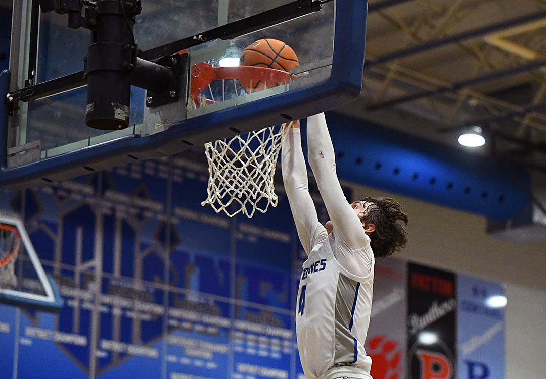 Polk County's Aaron Jackson dunks home two points during the Wolverines' late rally Tuesday