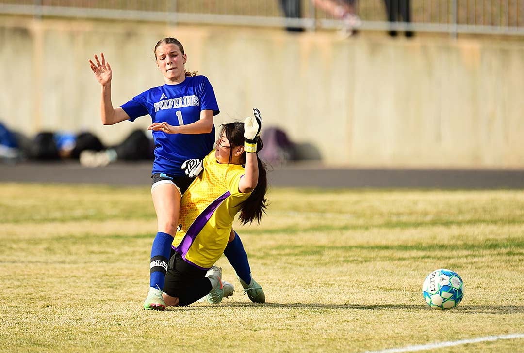 Polk County Middle's Kenley Savaia collides with Apple Valley's goalkeeper while making a run at a loose ball in the second half of Thursday's match